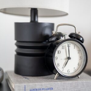 A black alarm clock sits on a book.
